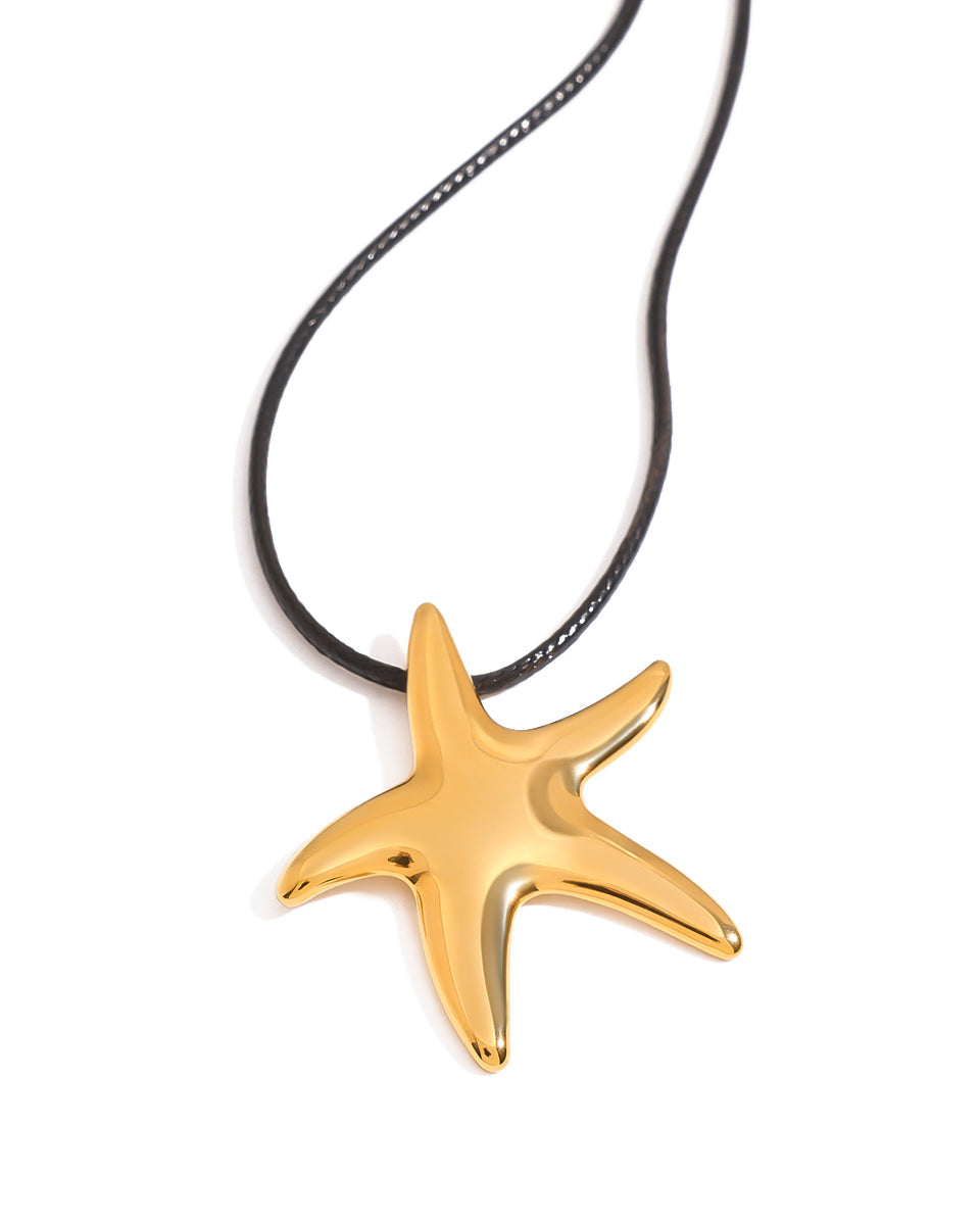 Gold starfish pendant on a black cord against a white background