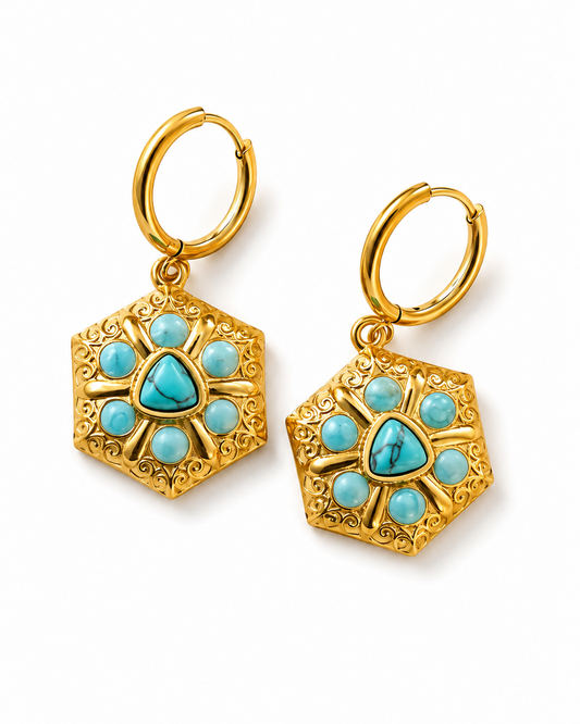 A pair of gold hoop earrings with hexagonal filigree pendants featuring turquoise blue stone accents, shown on a clean white background.