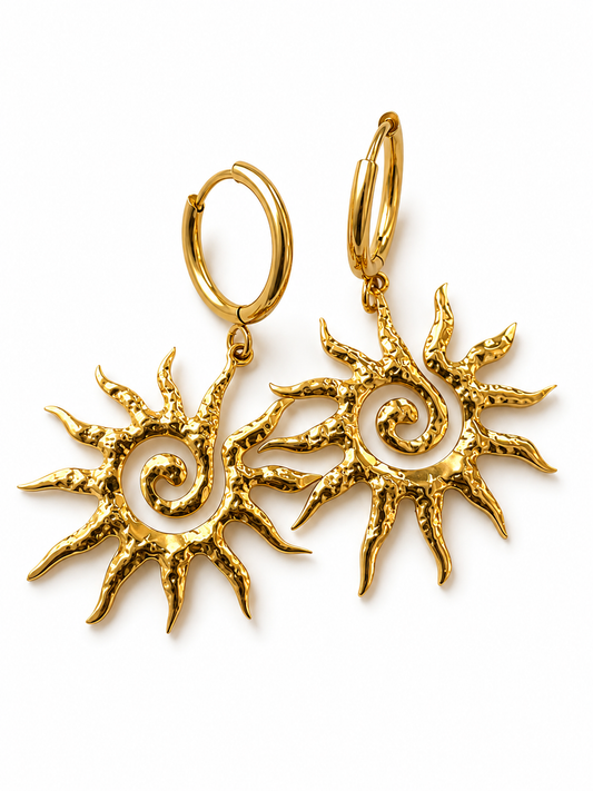 A pair of gold hoop earrings with dangling sunburst charms featuring textured, hammered edges and a spiral design in the center, shown on a plain white background.