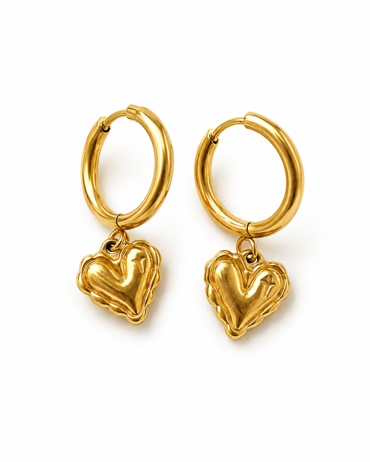 A pair of gold hoop earrings with dangling textured heart charms, shown on a clean white background.
