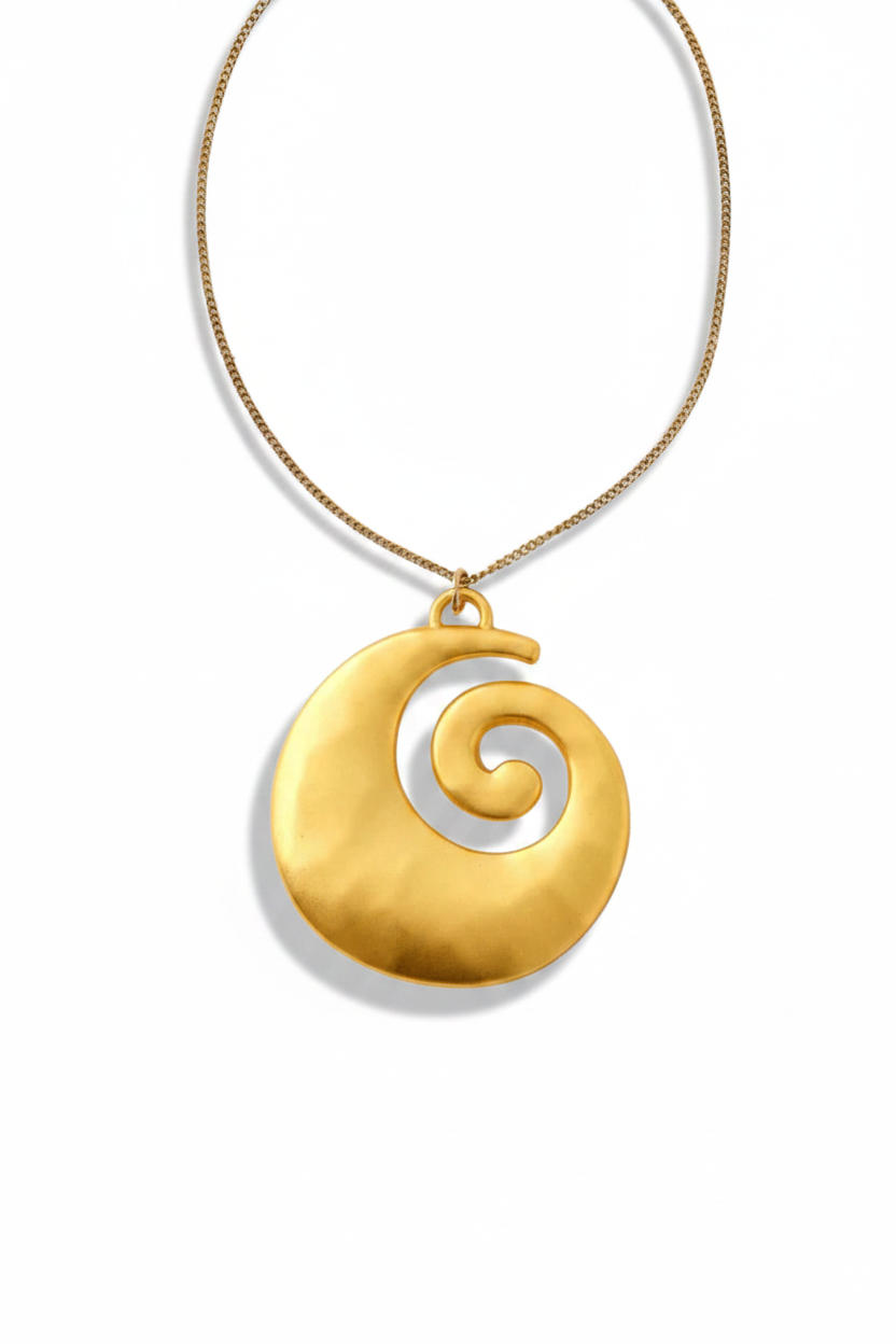 A gold necklace featuring a large, textured circular pendant with a spiral cutout design, suspended from a fine gold chain against a plain white background.